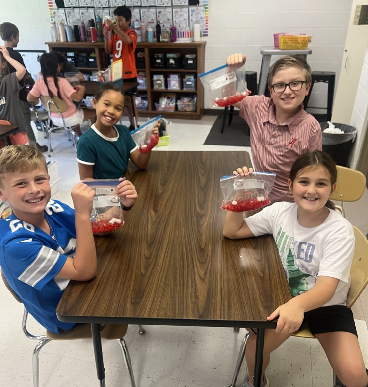 4th graders at their table posing with blood bags