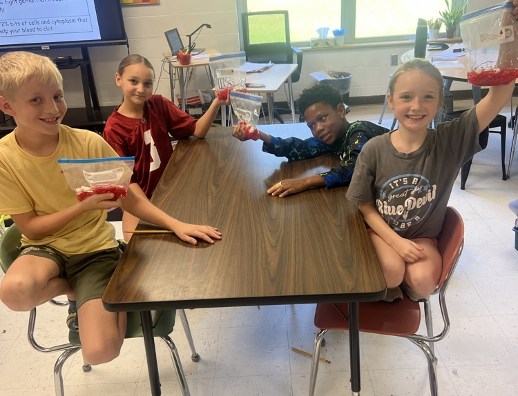 4th graders at their table posing with blood bags