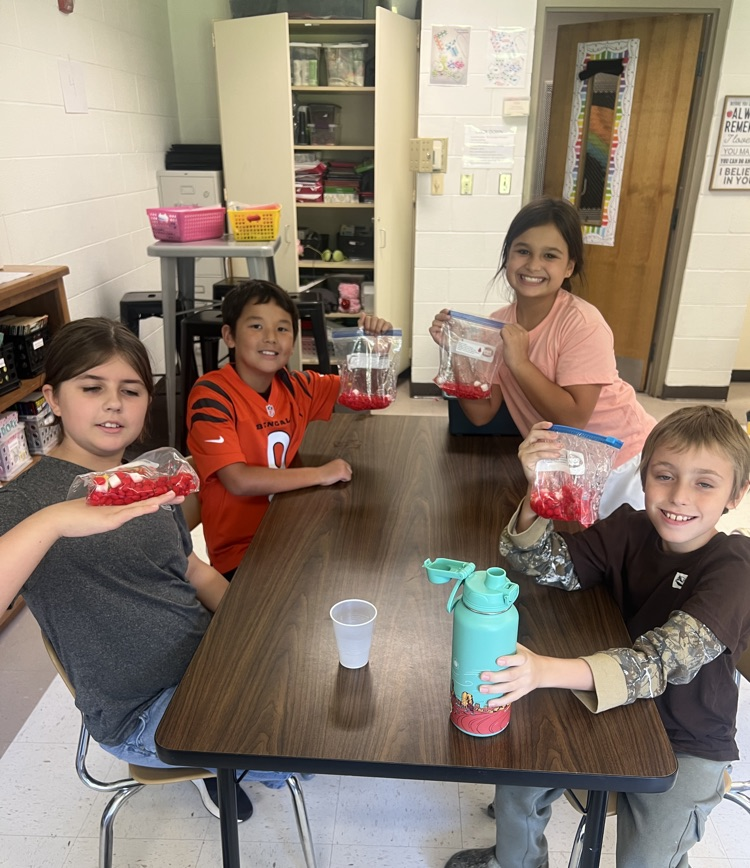 4th graders at their table posing with blood bags