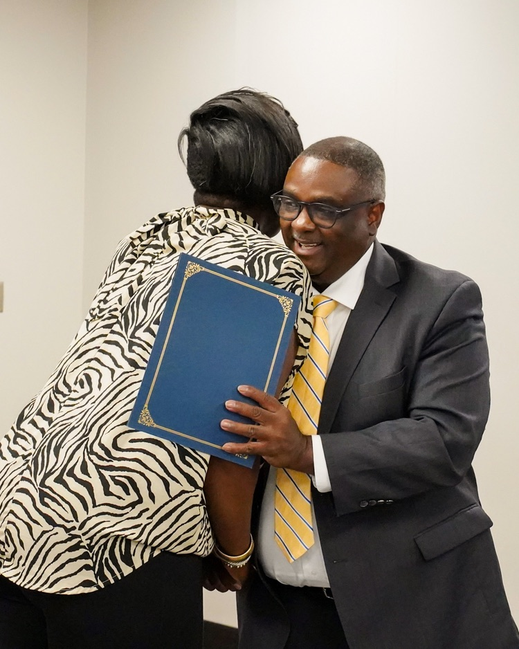 Tinker Rogers and Superintendent Dr. Walter Gonsoulin hug  