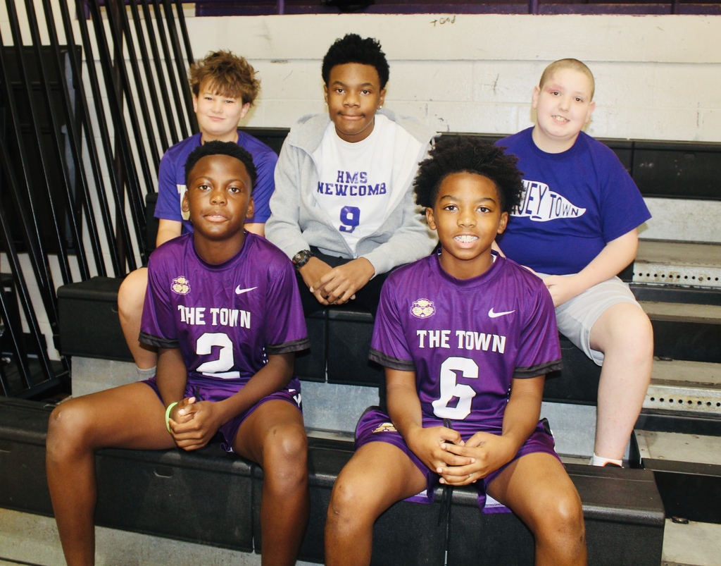 Five HMS students pose together in the gym wearing purple and Hueytown school gear.