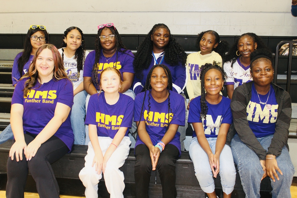 HMS students smile together in the gym while wearing purple for School Spirit Day.