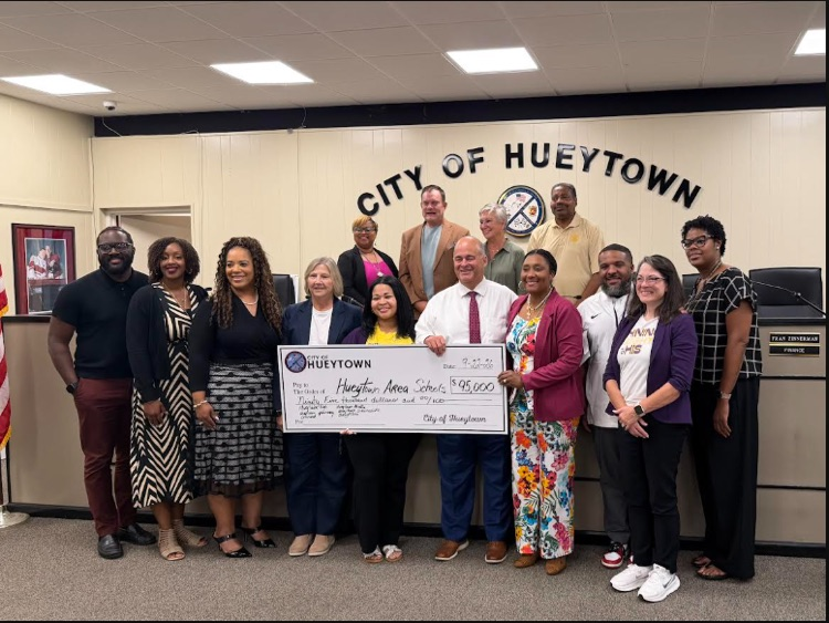 Hueytown city and school leaders pose at Hueytown City Hall with a $95,000 donation check for Hueytown area schools.