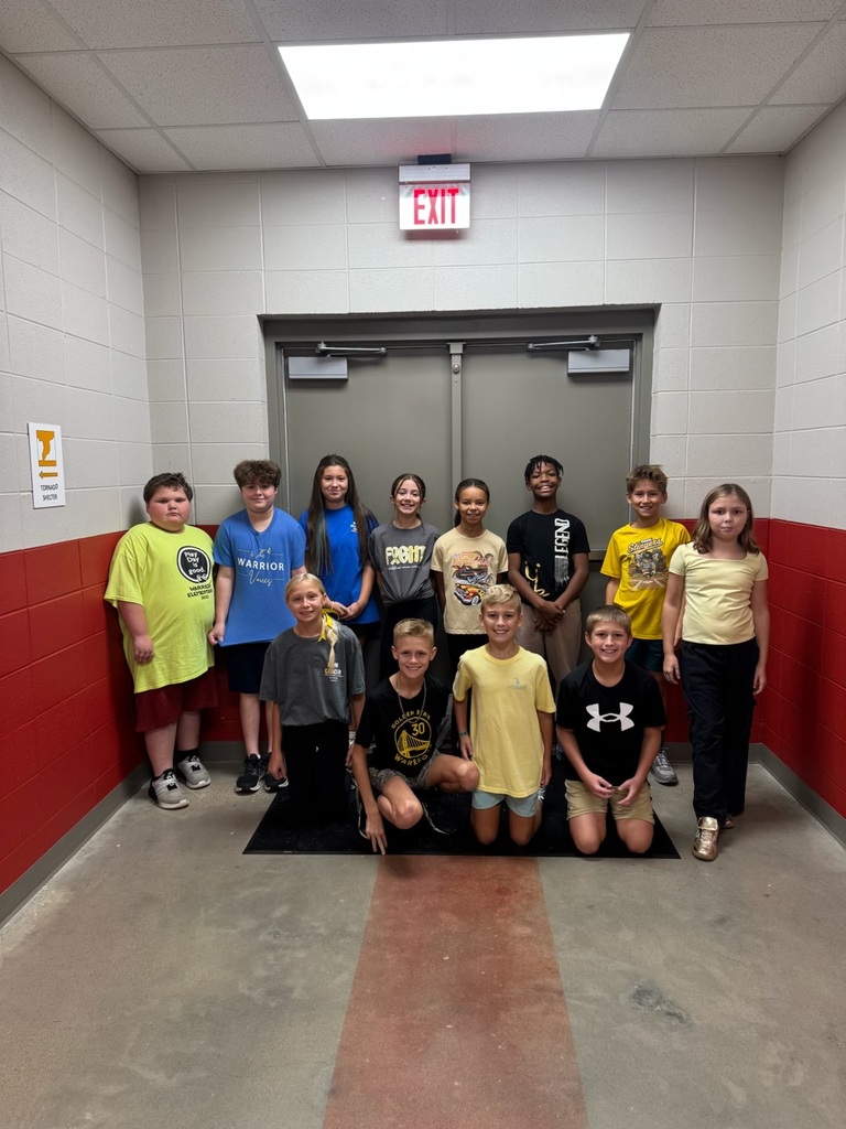 Students posing with class outside in the hallway showing their gold color clothing.