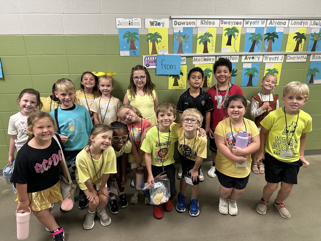 Students posing with class outside in the hallway showing their gold color clothing.
