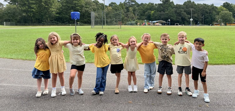 first graders on the playground in gold with their arms around each other