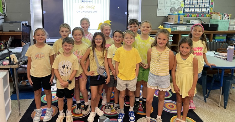 2nd graders in gold posing and smiling for the camera