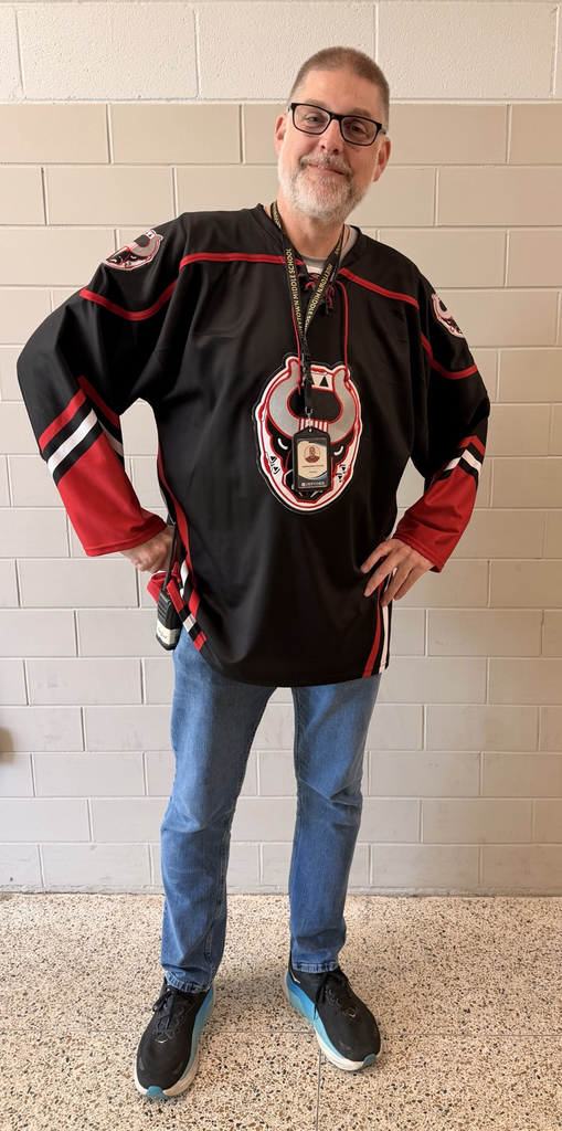 HMS staff member poses in a black and red hockey jersey.