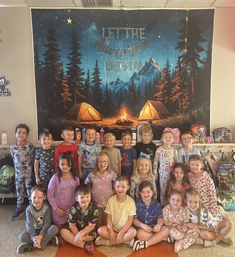 Kindergarten students posing in front of camping backdrop