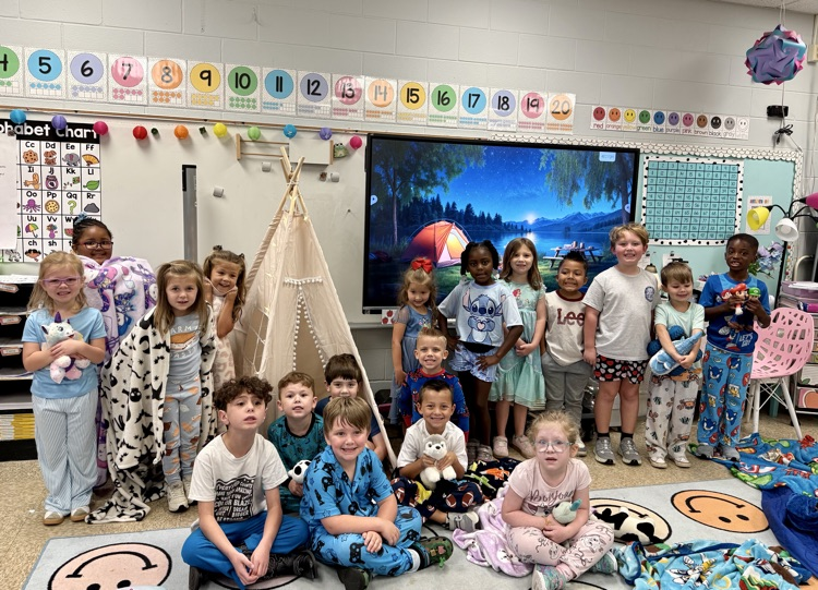 Kindergarten students posing in their pajamas in a classroom with a tent