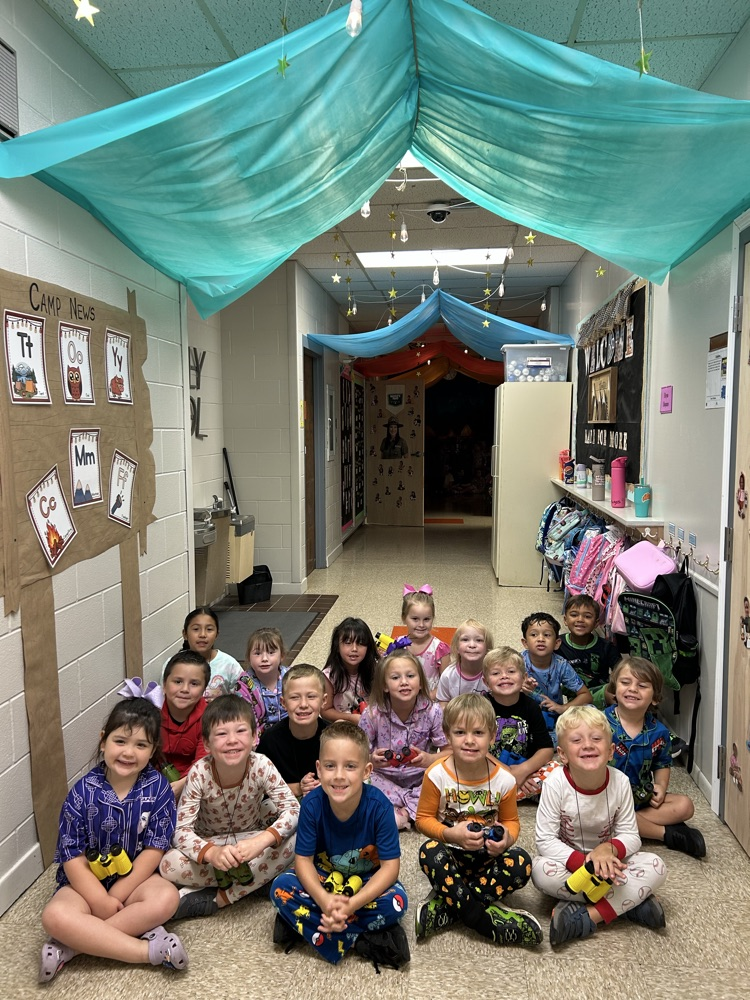 Kindergarten students smiling in the hall they had turned into tents