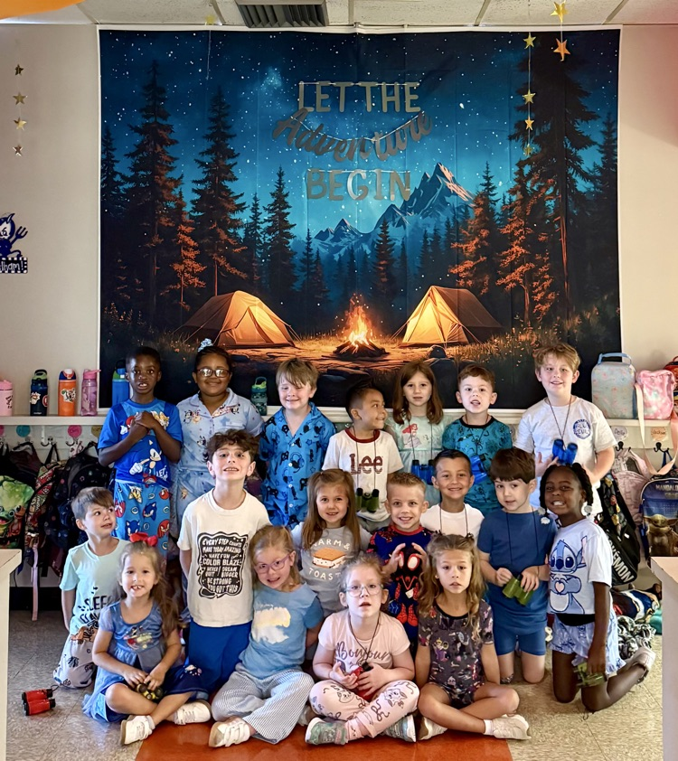 Kindergarten students posing in front of camping backdrop