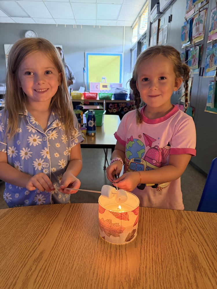two students making smores by candlelight