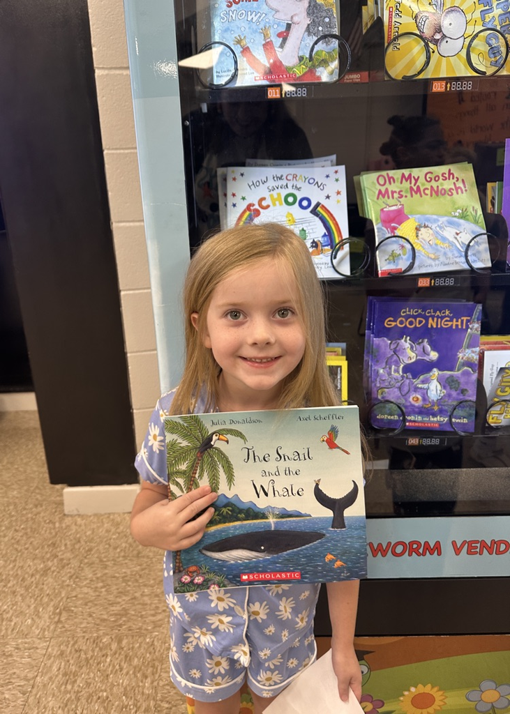 Kindergarten student smiling and holding a book