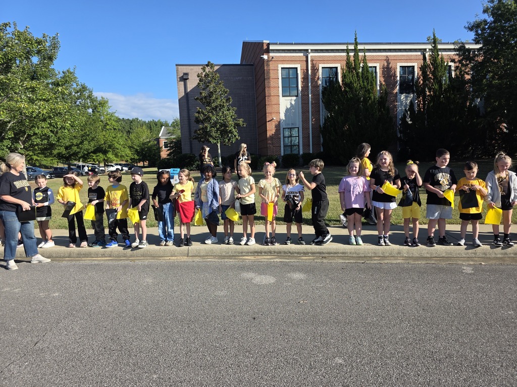 students standing on the sidewalk waiting for the parade to start