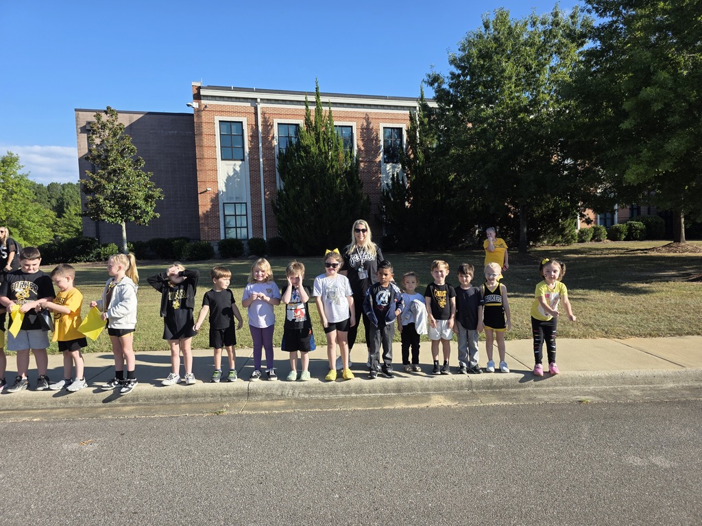 students standing on the sidewalk waiting for the parade to start