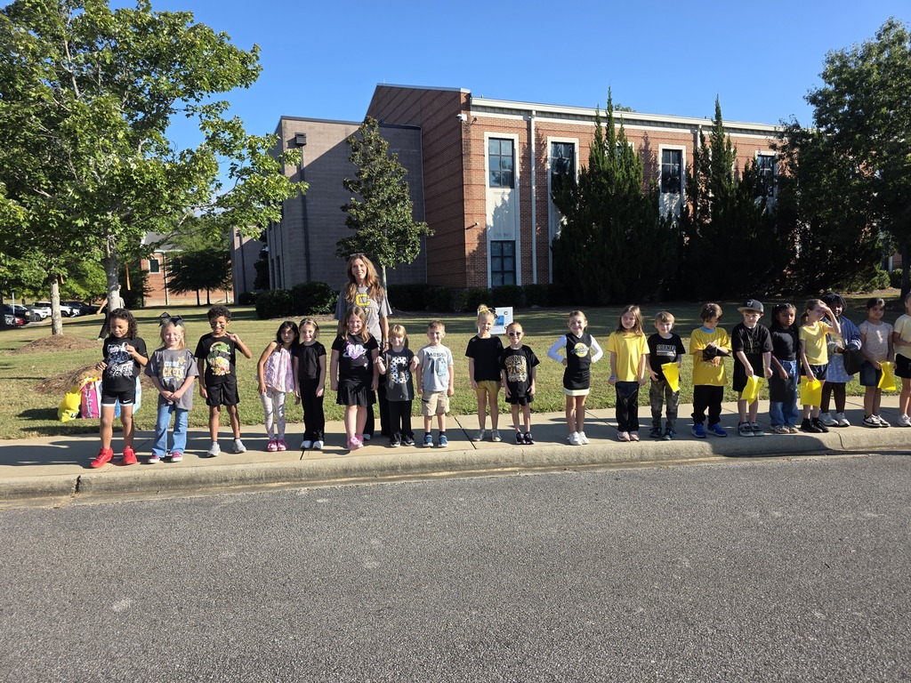 students standing on the sidewalk waiting for the parade to start