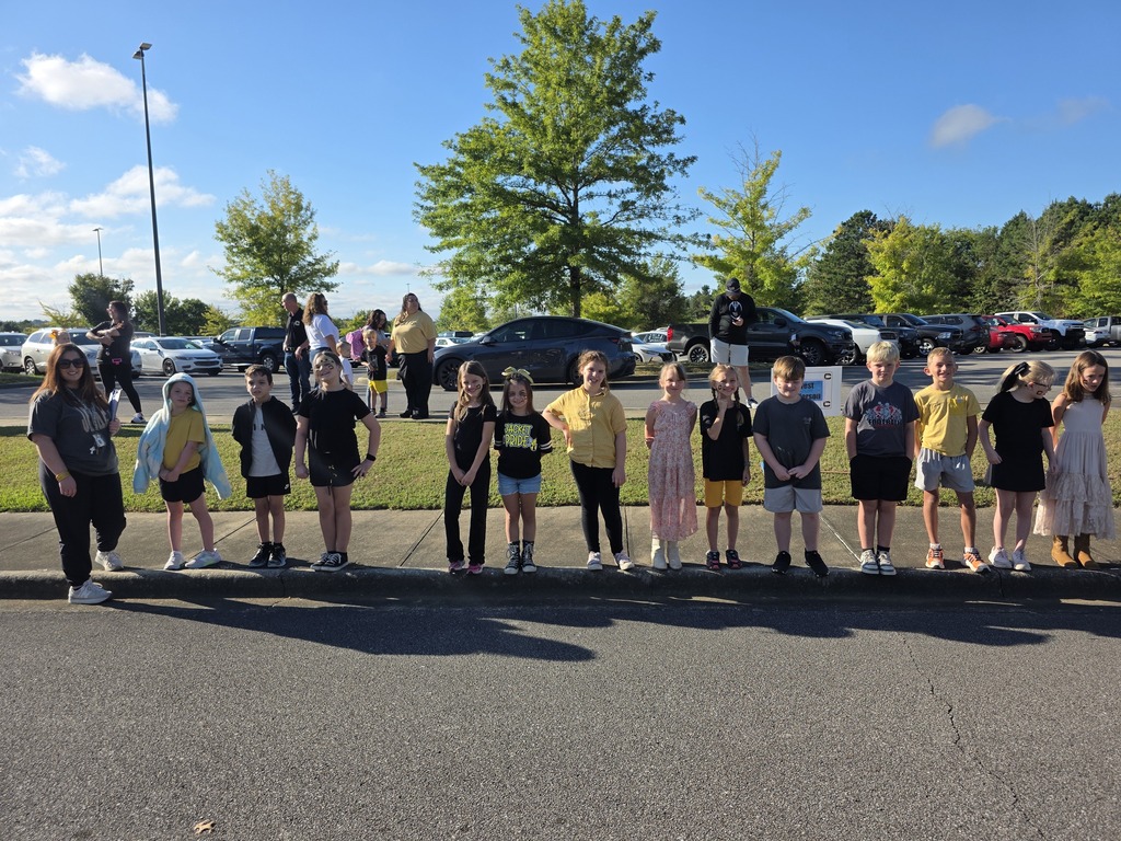 students standing on the sidewalk waiting for the parade to start