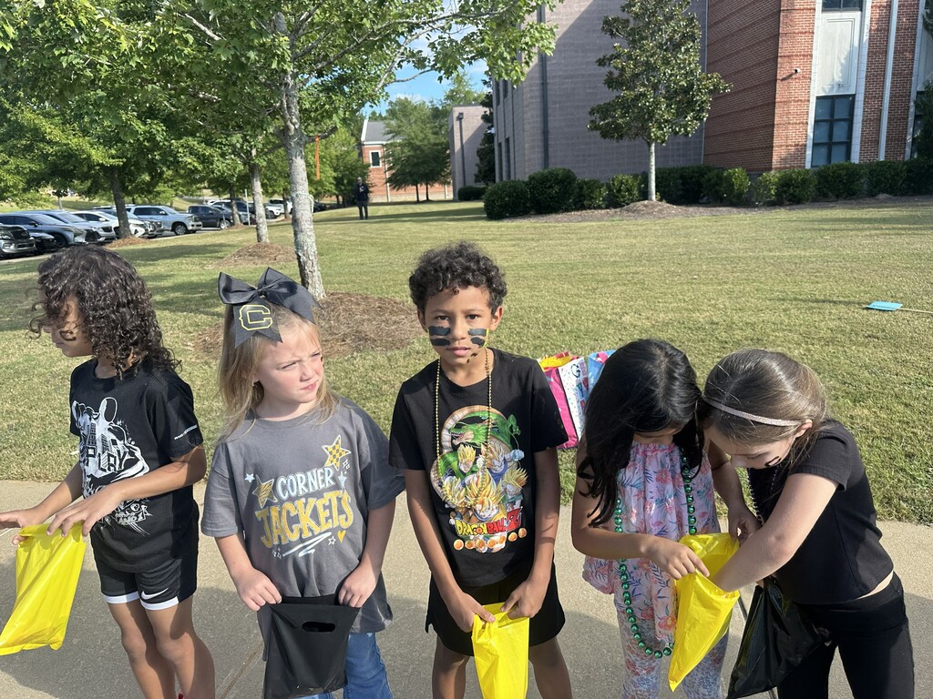 students standing on the sidewalk catching candy from the parade