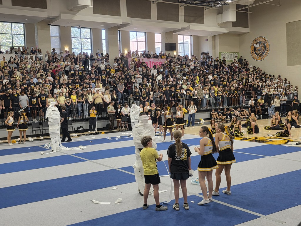 People sitting in the bleachers watching teachers get rolled with toilet paper