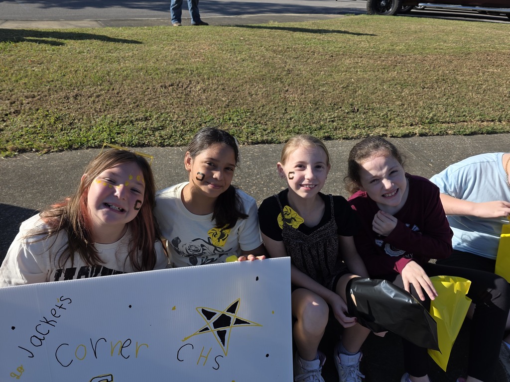 4 students sitting on the sidewalk