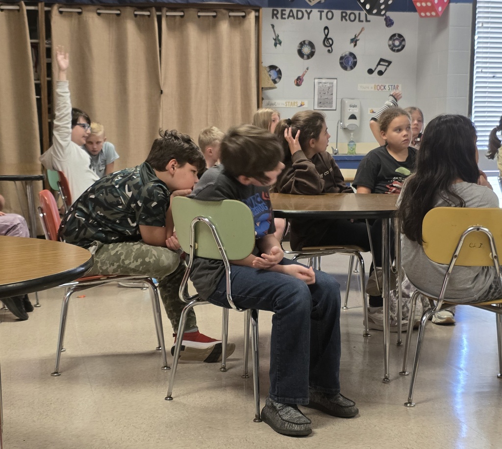 group of students sitting in chairs listening to a guest speaker
