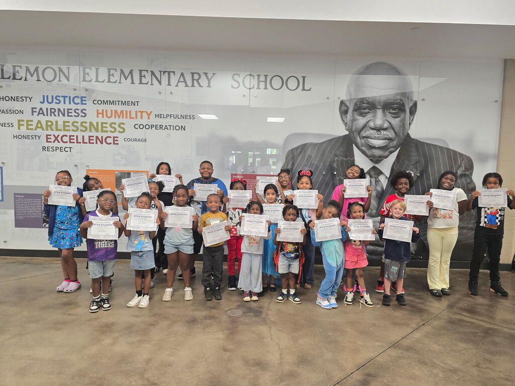 Students of the Week holding their certificates in front the the Judge Clemon mural.