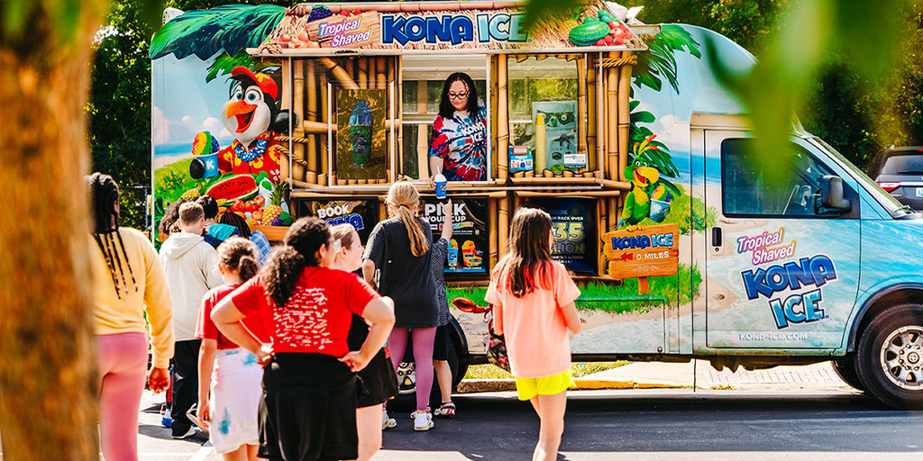 People standing in line at a Kona Ice truck