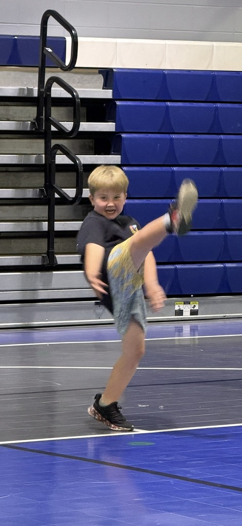 Student kicking his leg up in martial arts class in PE