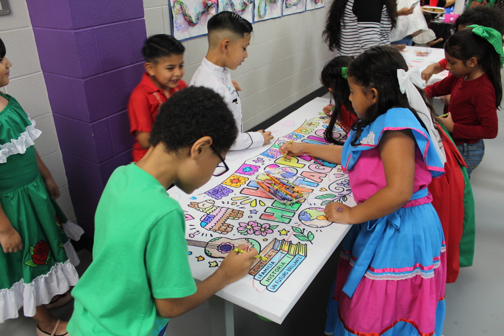 students coloring a large coloring page that says Hispanic Heritage Month