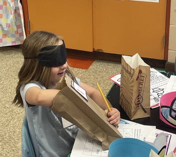 a blindfolded student using her sense of touch