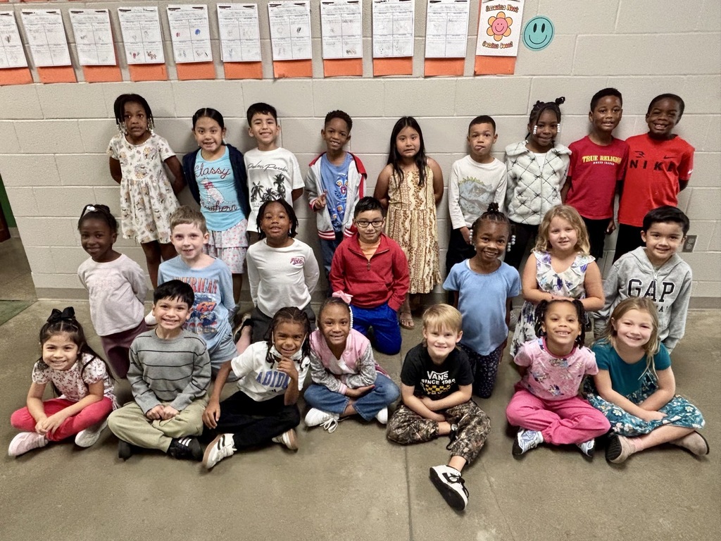 Group photo of the First Grade Students of the Month smiling together and being recognized for their positive behavior, leadership, and hard work at school.