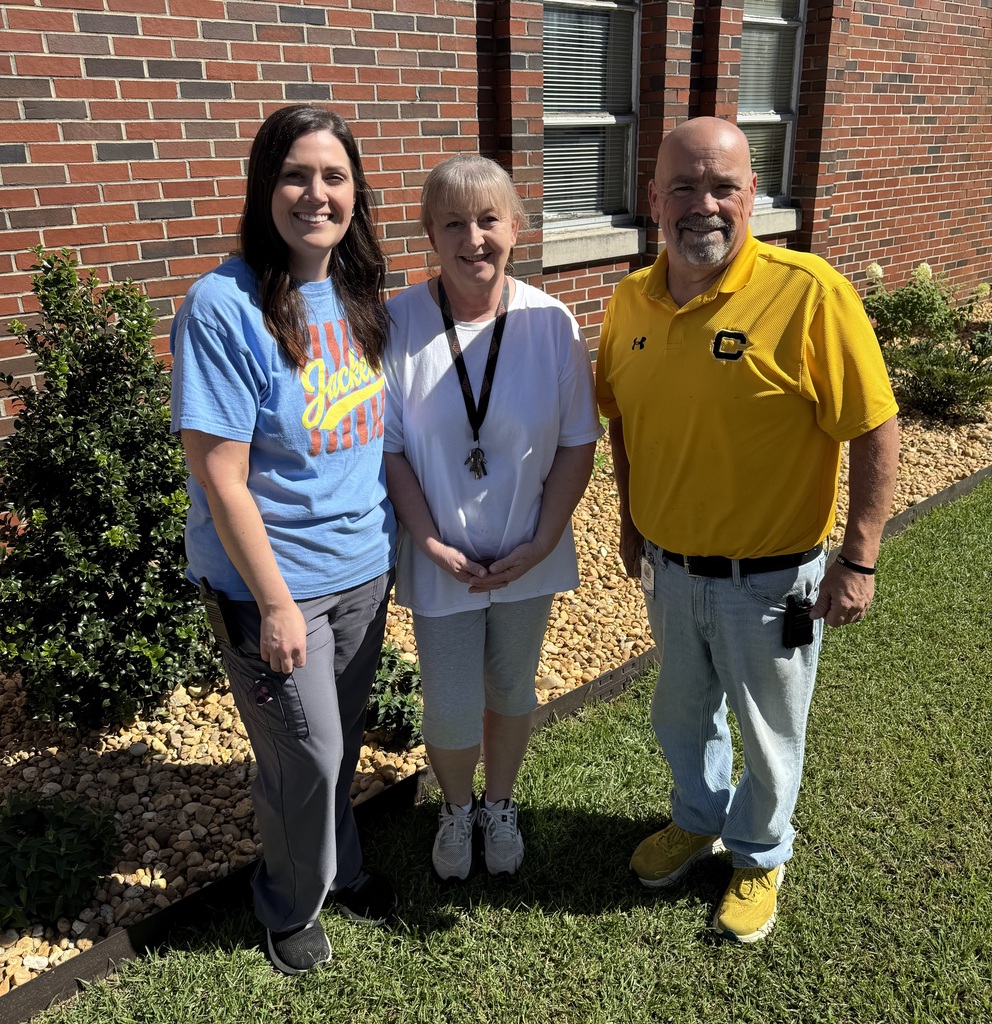 Two ladies and one gentleman outside in front of a brick building