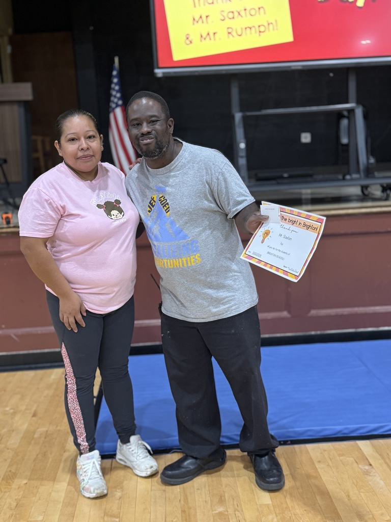 a man and a woman standing and holding an award and gift card