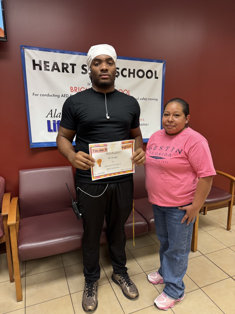 a man and a woman standing and holding an award and gift card