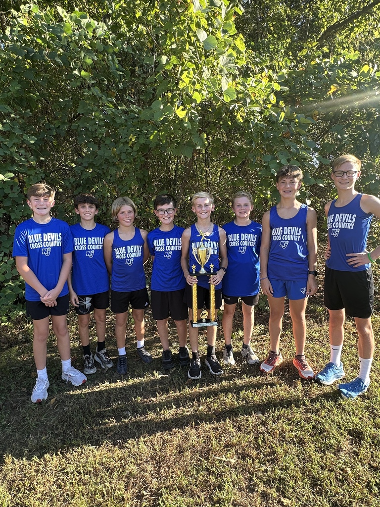 The boys cross country team in a row with their trophy