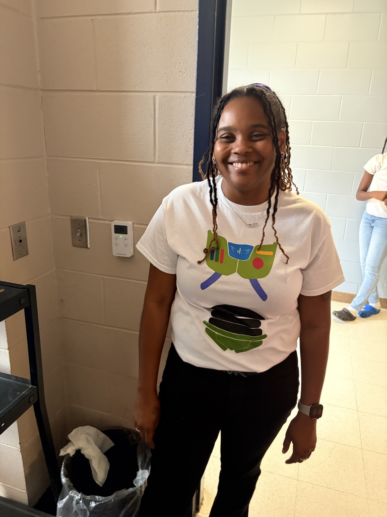 Teacher wearing white shirt with green aliens