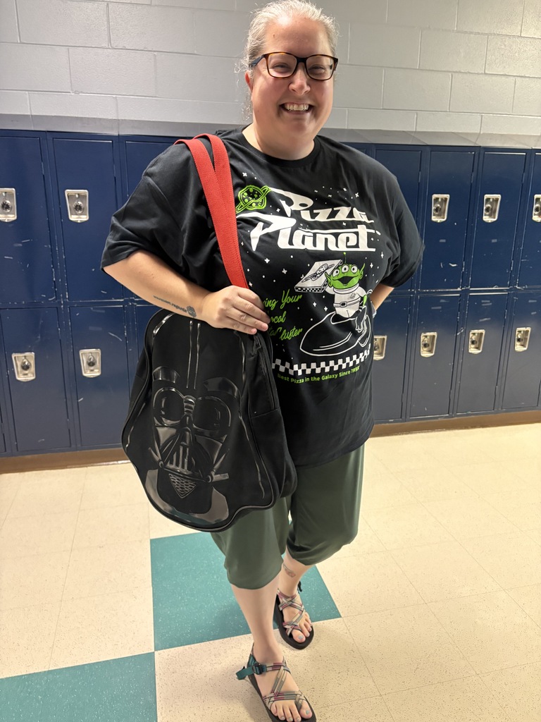 Woman carrying a darth Vader purse and black shirt.