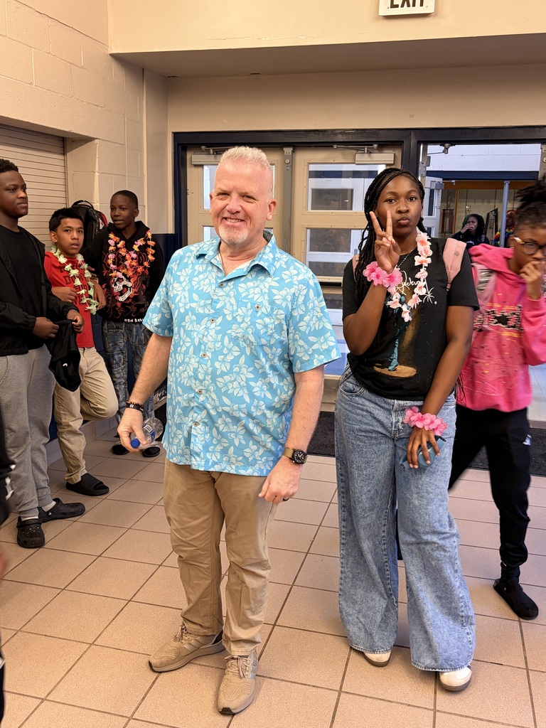 Principal in blue palm tree shirt and student wearing lei