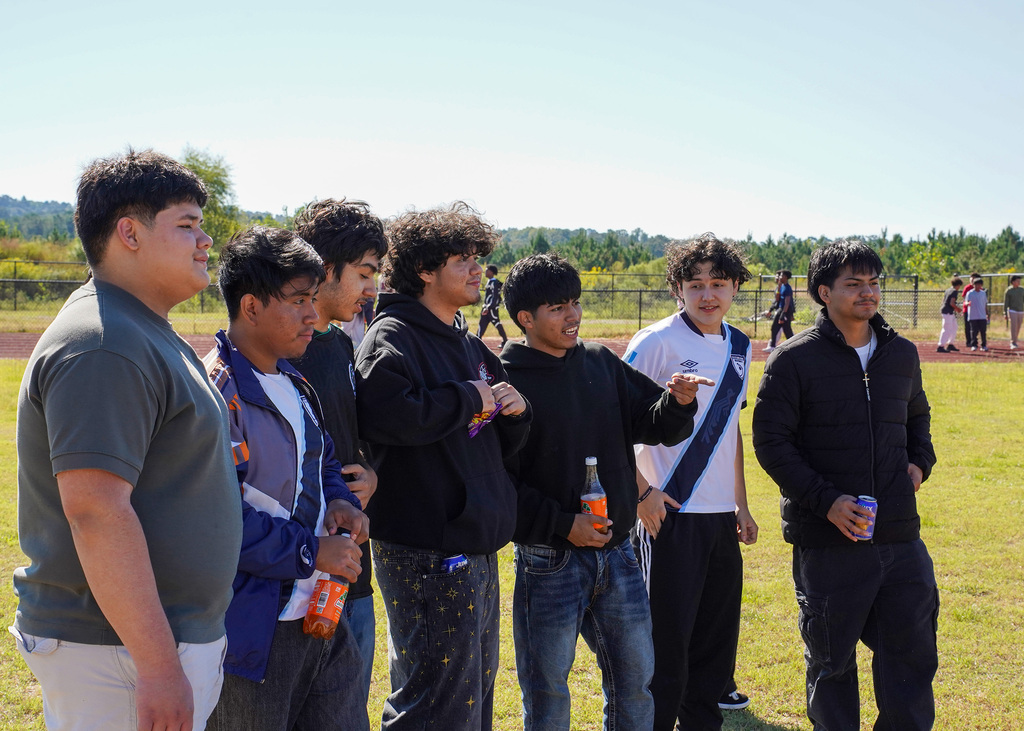 A group of students stand together outdoors.
