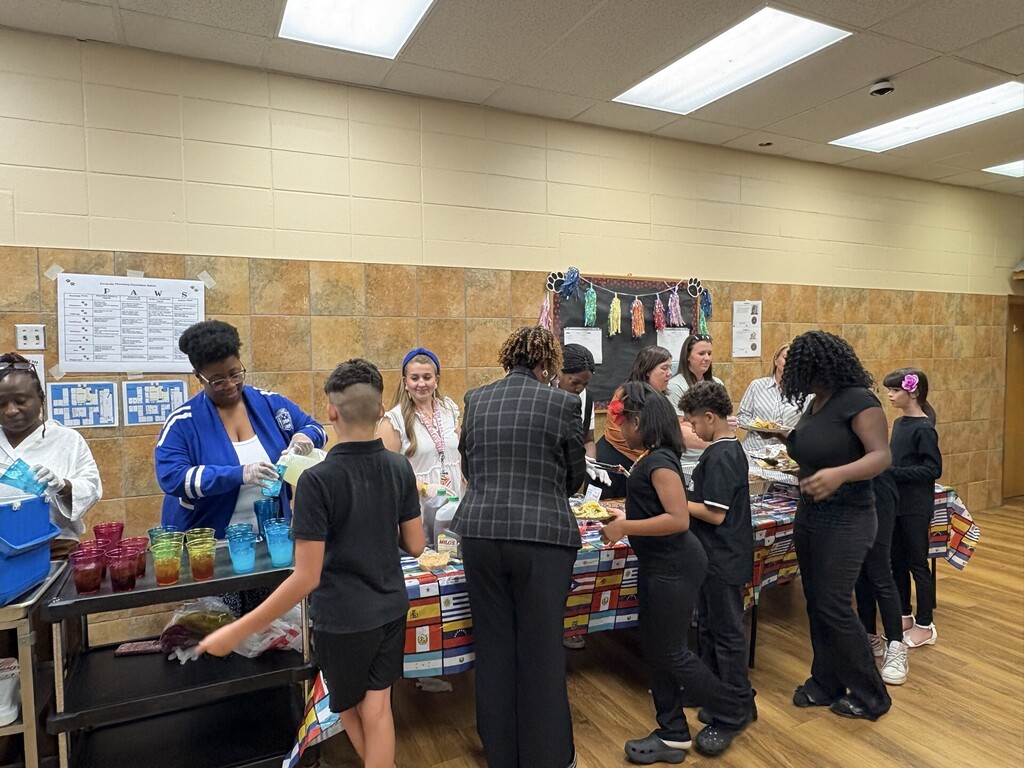 Principal and teachers serving food to students. 