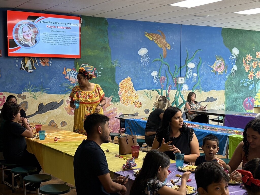 Parents eating in the lunchroom, Ms. Bates assisting. 