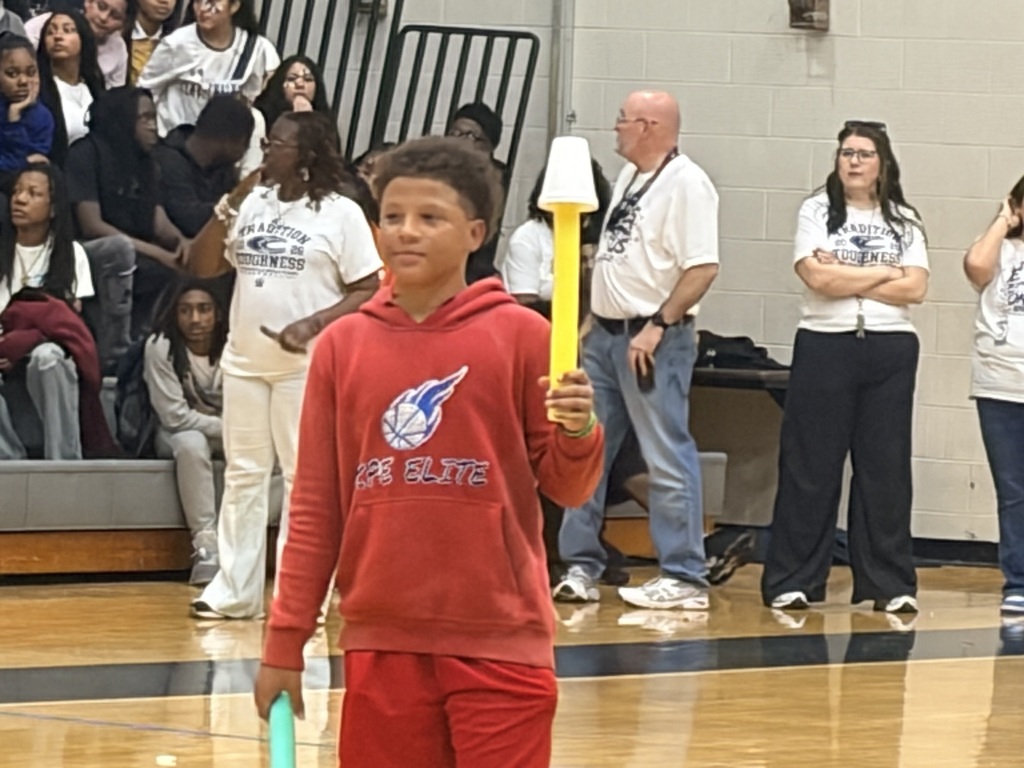 Boy dressed in red with a pool noodle and cup