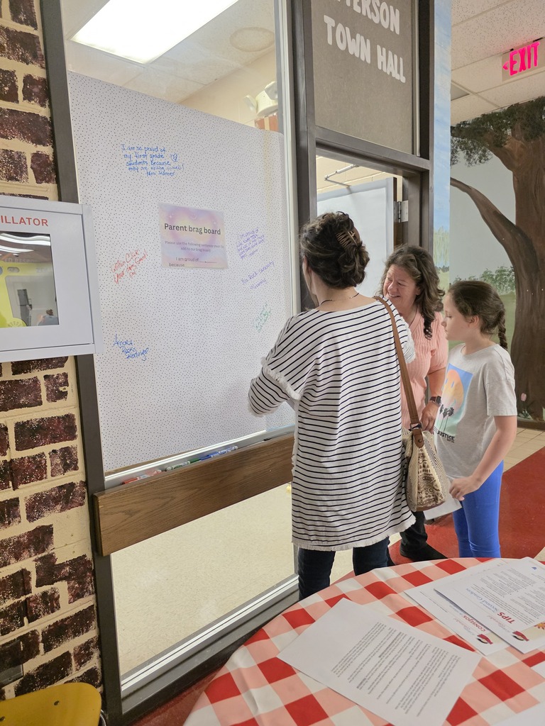 parents writing on a poster hung on the wall