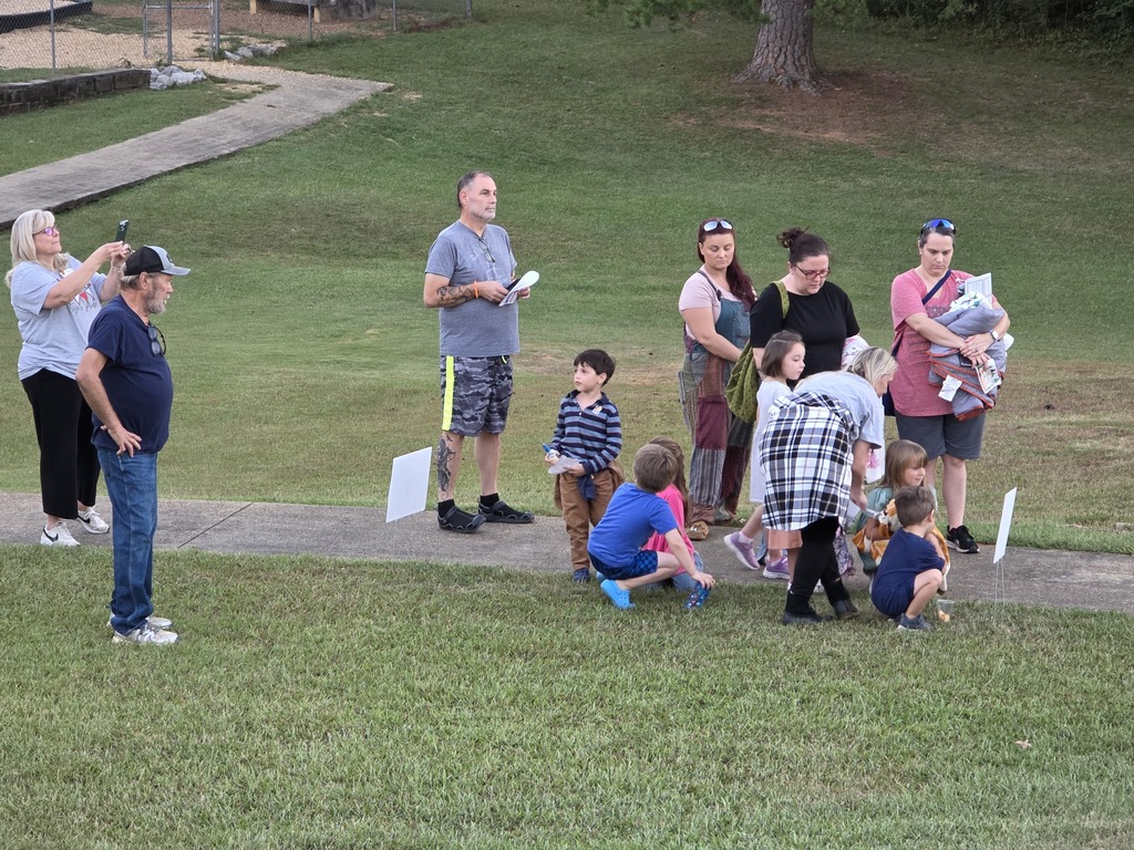 parents and students reading a story along a pathway