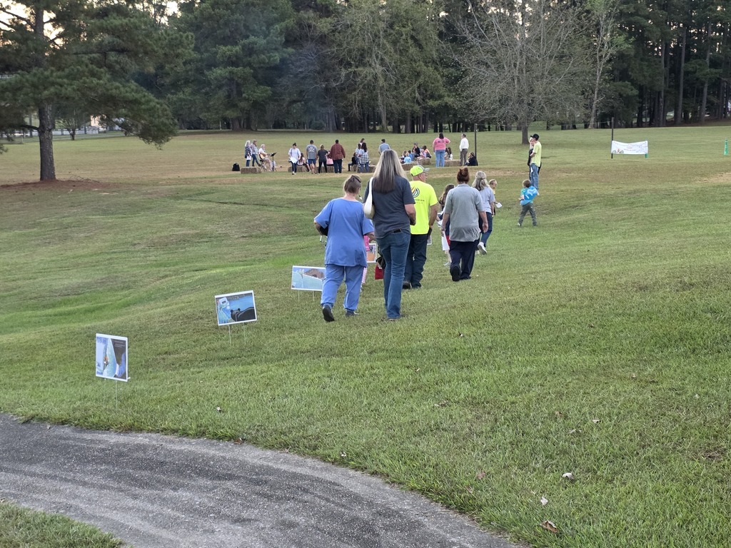 parents and students reading a story along a pathway