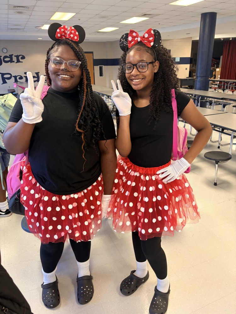 Gitls wearing red and white polka dot skirt and Mickey Mouse ears