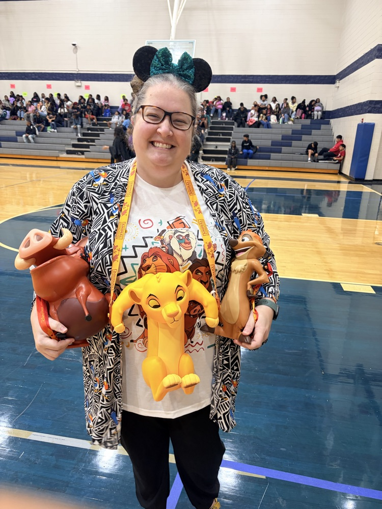 Woman wearing printed shirt and carrying Disney characters from lion king