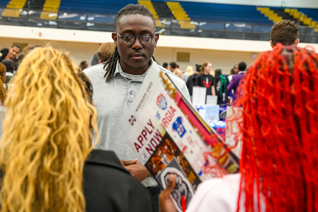 Students speak to a college recruiter during a career fair.