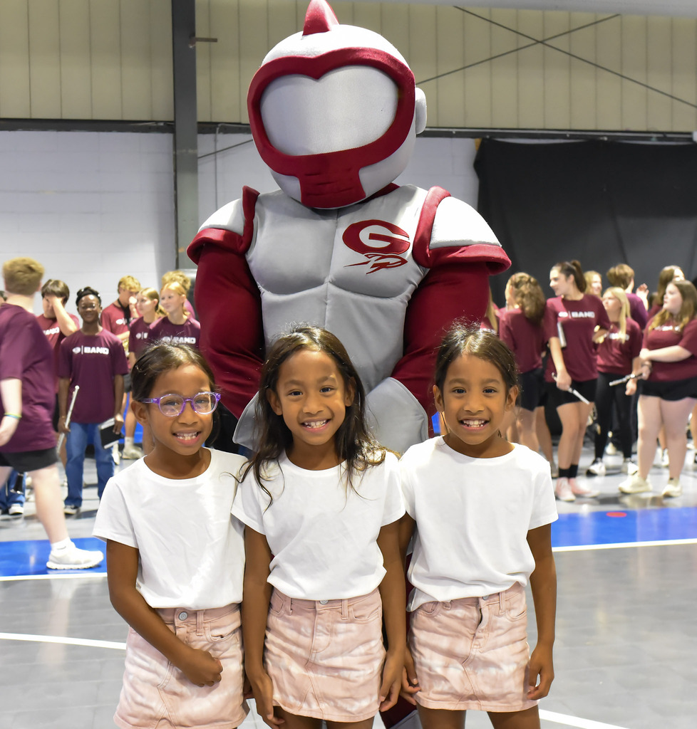 Triplets posing with Rocket mascot
